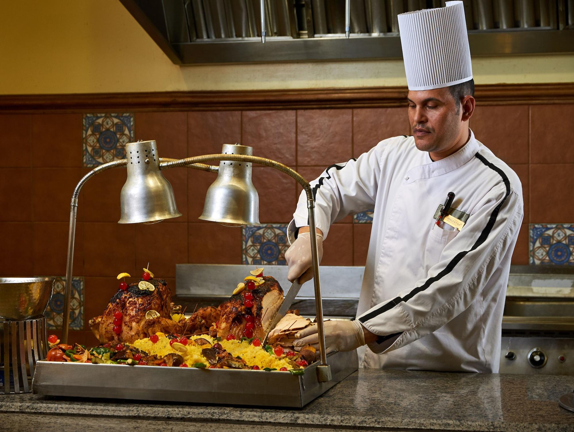 Mosaique Beach Resort Taba Heights Extérieur photo A chef carving a roast